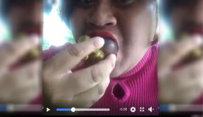 Wanita makan manggis dengan kulit dan bijinya.