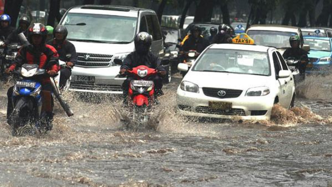 Sejumlah pengendara menerjang air yang menggenangi Jalan Jenderal Sudirman