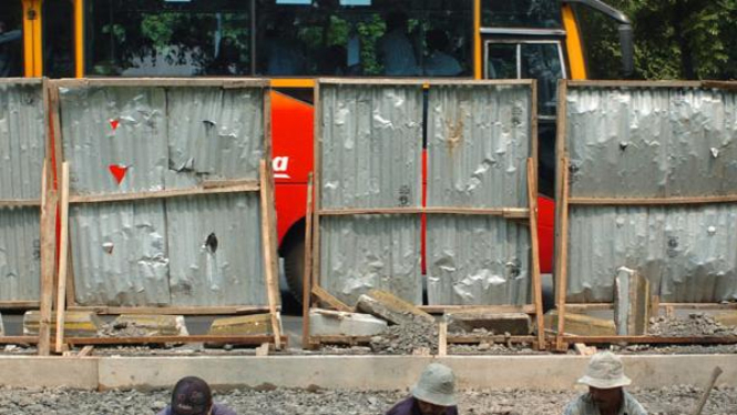 Tiga pekerja memperbaiki jalur Transjakarta 