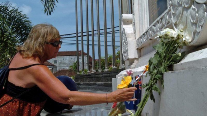 Seorang turis meletakan bunga di altar monumen bom Bali 