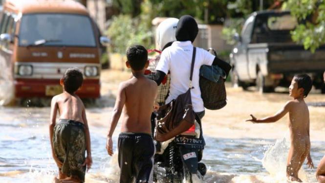Anak-Anak Siap Mendorong Kendaraan Mogok Akibat Banjir di Samarinda