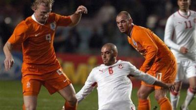 Dirk Kuyt (kiri) mengecoh pemain Tunisia Houcine Ragued