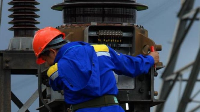Petugas PLN tengah memperbaiki jaringan listrik di Gardu Induk Gandul, Jakarta.