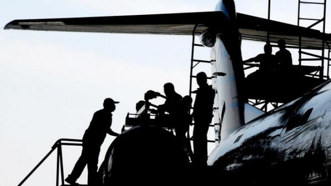 Sejumlah teknisi memeriksa beberapa bagian pesawat di bengkel Merpati, Surabaya.