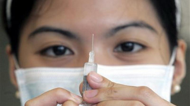 Seorang perawat di Filipina menyiapkan vaksin anti flu 