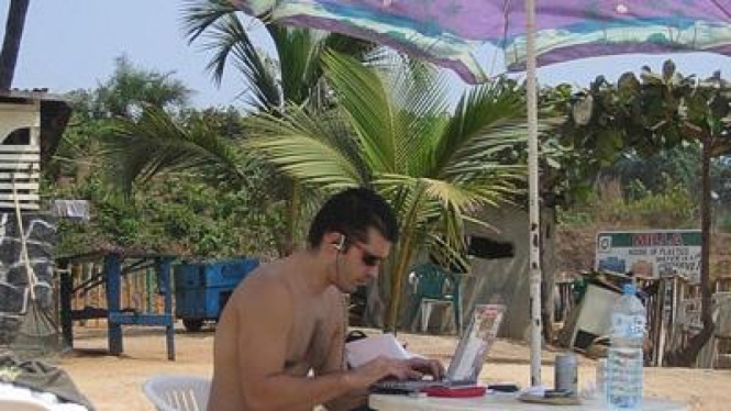 Kerja di pantai dengan notebook dan hotspot wifi gratis