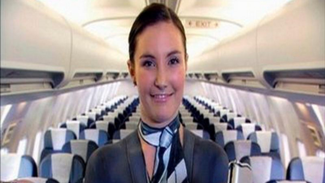 Seorang pramugari Air New Zealand memperlihatkan sabuk pengaman