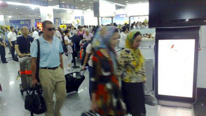 Para calon penumpang pesawat di bandar udara Urumqi, China 