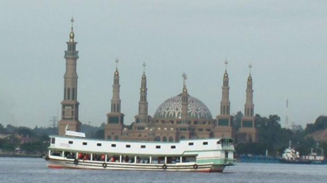 kapal lintasi Sungai Mahakam, berlatar Masjid Islamic Centre Samarinda