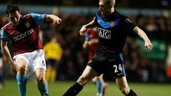 Pemain MU Darren Fletcher (hitam) dan pemain Aston Villa Stuart Downing