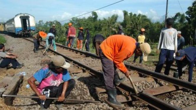 mengganti bantalan rel kereta api yang anjlok 