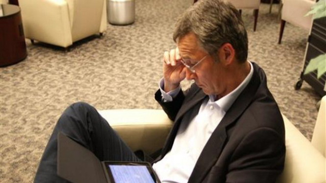 PM Norwegia, Jens Stoltenberg, bekerja dengan iPad di Bandara Newark, AS