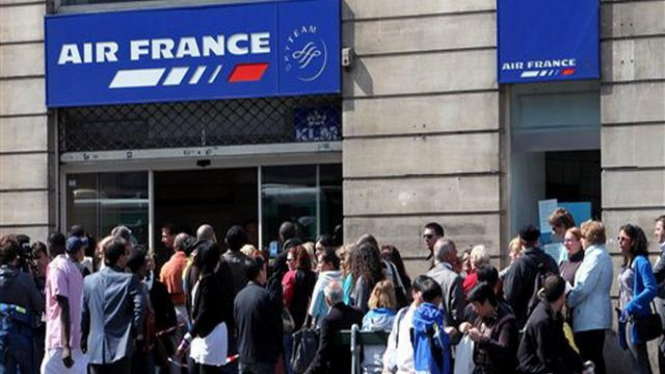 Para calon penumpang mengantri di depan kantor Air France di Paris, Prancis