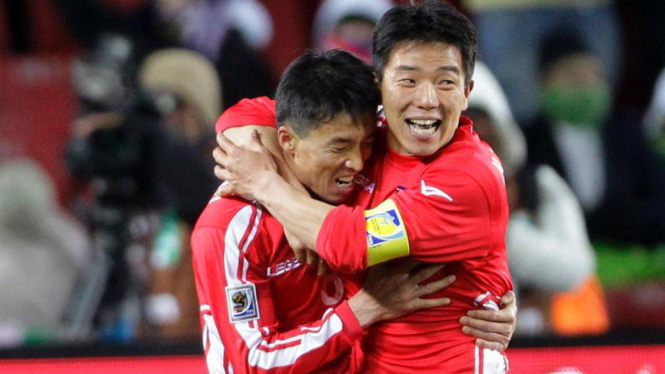 Pemain Korea Utara Ji Yum Nam (kiri) merayakan golnya.