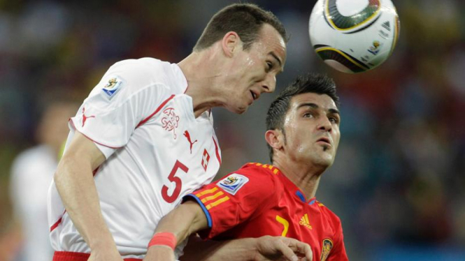 Pemain Spanyol, David Villa (kanan) berebut bola dengan pemain Swiss.