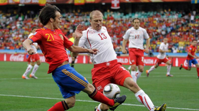 Pemain Spanyol, David Silva (kiri) dan pemain Swiss Stephane Grichting. 