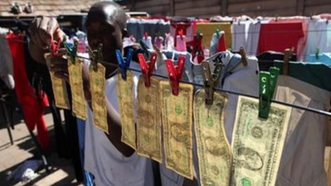 Seorang pria di Kota Harare, Zimbabwe, menjemur sejumlah uang dolar