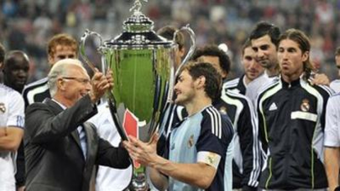 Iker Casillas menerima trofi kemenangan dari Beckenbauer