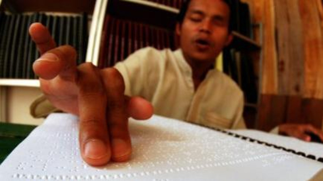 Seorang tunanetra, Sofian (22), membaca Al Quran braille