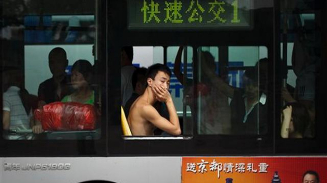 Penumpang bus di Beijing menanggalkan baju di tengah cuaca panas