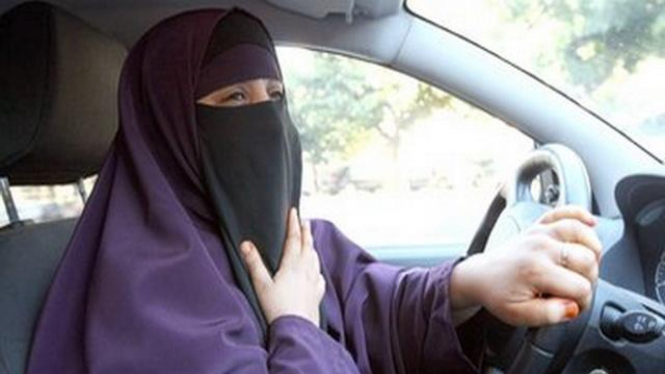 Seorang perempuan Prancis berkendara sambil mengenakan burqa