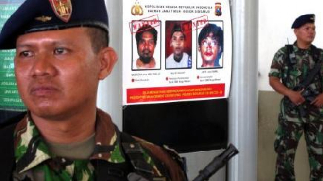 Personel TNI berjaga-jaga di dekat poster sejumlah teroris yang jadi buronan Polri beberapa waktu silam.  