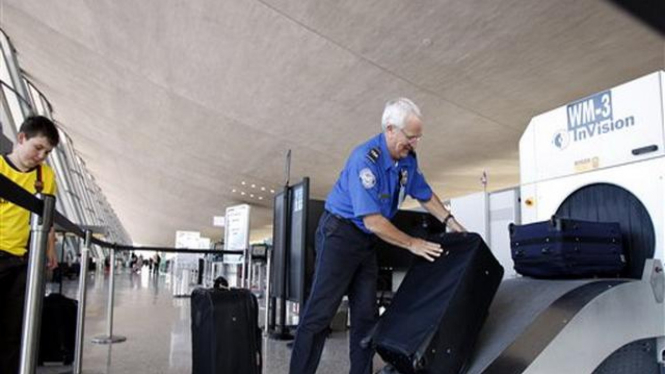 Petugas keamanan Bandara Dulles, AS, memeriksa koper calon penumpang