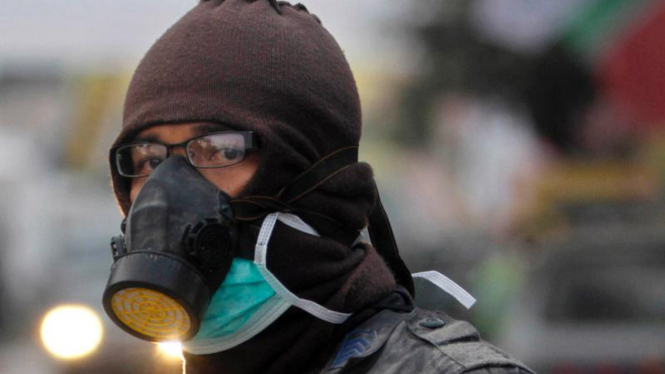 Polisi mengenakan masker agar tak menghirup abu Merapi