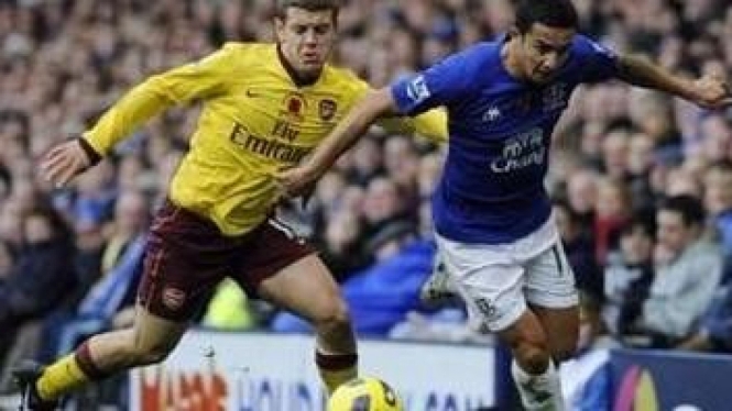 Pemain Arsenal Jack Wilshere (kuning) dan Tim Cahill 