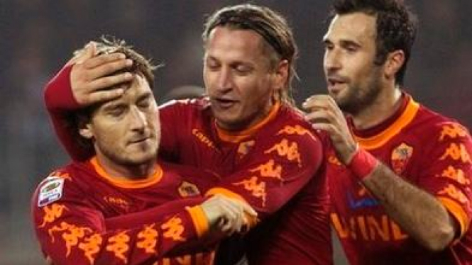 Francesco Totti (paling kiri) merayakan gol