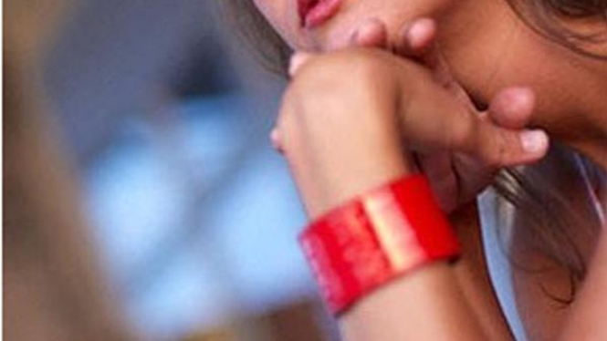 Wanita kenakan gelang merah