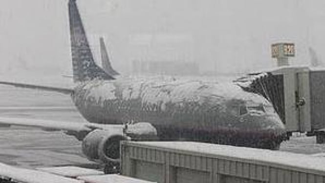 Pesawat diselimuti salju di bandara