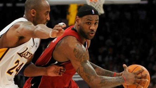 LeBron James (kanan) berusaha melewati Kobe Bryant