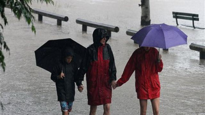 Penduduk kota Brisbane, Australia, mengarungi jalanan yang banjir
