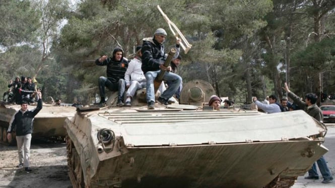 Warga Libya menaiki tank milik militer.