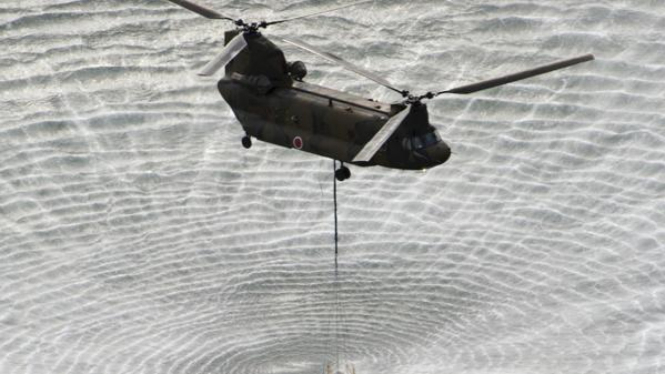 Helikopter militer Jepang mengambil air laut .