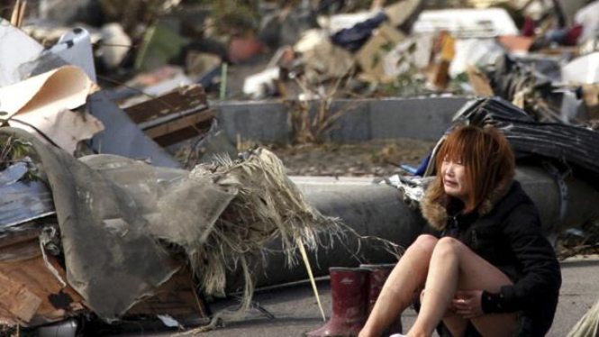 Wanita di Natori, Jepang utara, meratapi reruntuhan rumahnya.