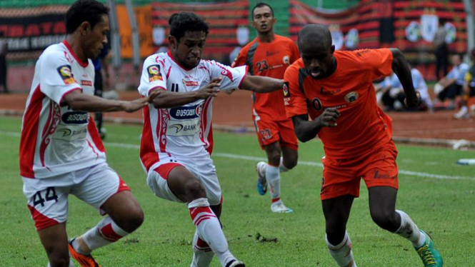 Greg Nwokolo berebut bola dengan Imanuel Wanggai dan Yohanis Tjo-E, dalam lanjutan LSI 2010/2011 di SGUBK, Jakarta, Kamis (31/3/2011). 