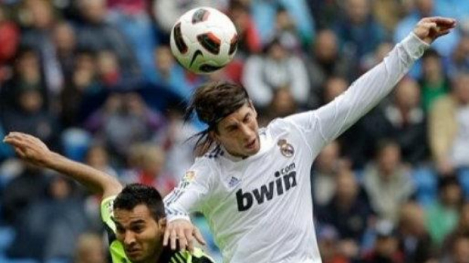 Sergio Ramos (Madrid/putih) berebut bola dengan pemain Zaragoza