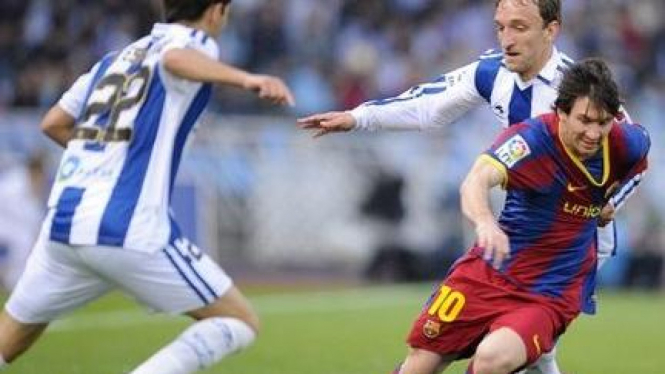 Lionel Messi berusaha lepas dari kawalan pemain Sociedad