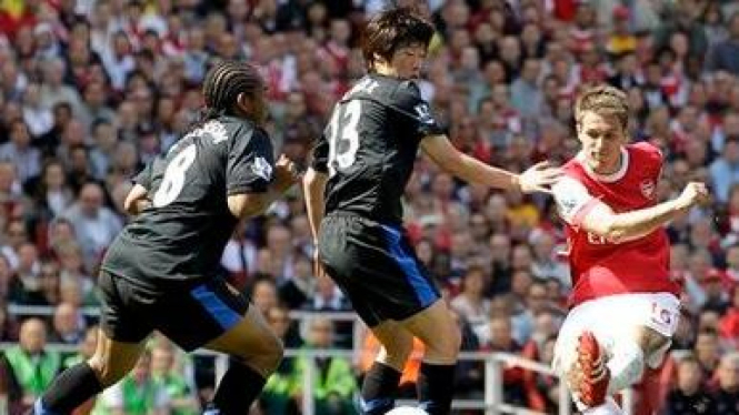 Aaron Ramsey (Arsenal/merah) melepaskan tendangan
