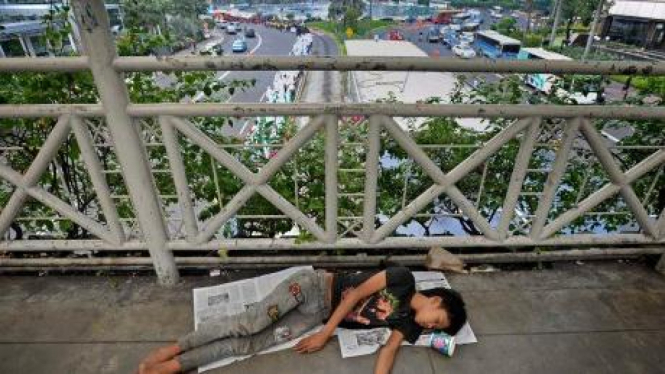 tunawisma tidur di atas jembatan penyeberangan jalan MH Thamrin, Jakarta