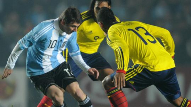 Lionel Messi (Kiri ) dihadang dua pemain Kolombia