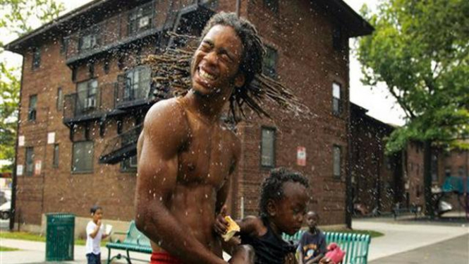 Seorang warga bersama anaknya di Newark, AS, mandi bersama
