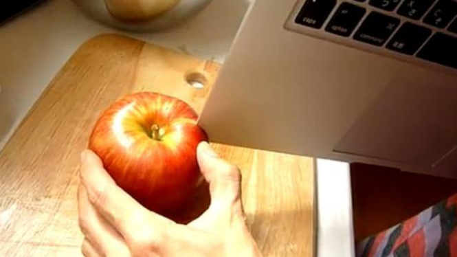 MacBook Air digunakan sebagai pisau untuk memotong apel