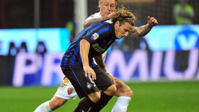 Diego Forlan (biru-hitam) dikawal Simon Kjaer