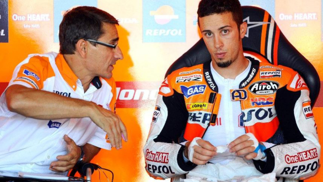 Andrea Dovizioso (Repsol Honda/kanan) mendengarkan mekanik tim