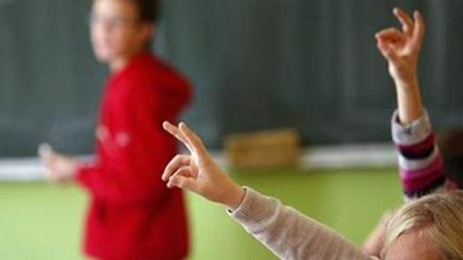 Siswa sekolah dasar mengacungkan tangan