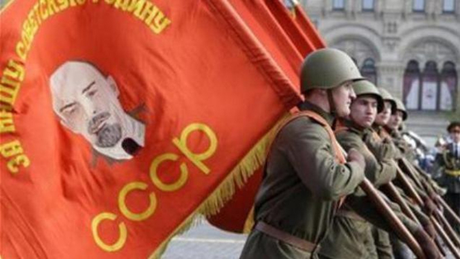 Tentara Rusia membawa bendera bergambar Lenin di Moskow