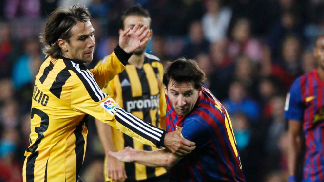 Pemain Barcelona Lionel Messi (kanan) dihadang pemain Zaragoza